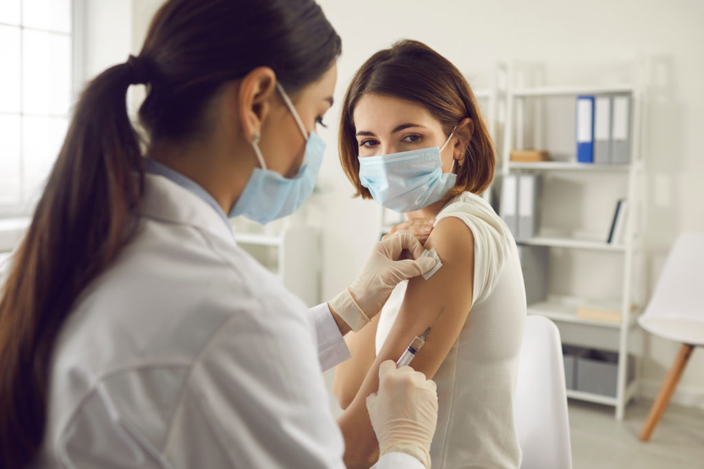 Profissional da saúde aplicando vacinas em um consultório médico